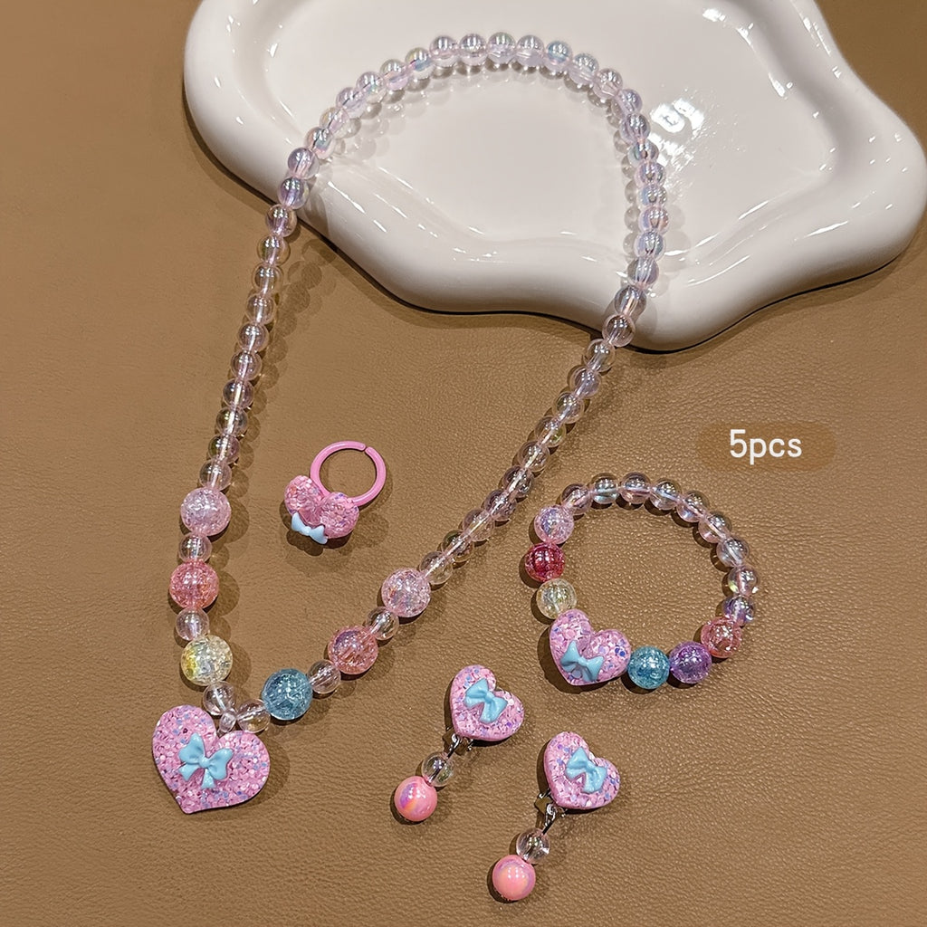 Conjunto de Joyería Infantil de 5 Piezas: Collar, Pulsera, Anillo y Aretes con Dije de Corazón Brillante y Lazo (Tonos Rosas)