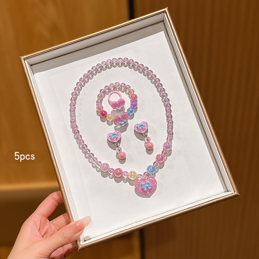 Conjunto de Joyería Infantil de 5 Piezas: Collar, Pulsera, Anillo y Aretes con Dije de Corazón Brillante y Lazo (Tonos Rosas)