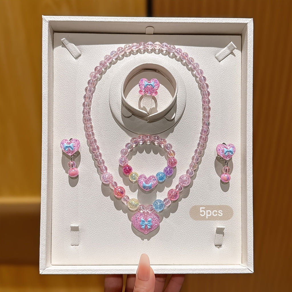 Conjunto de Joyería Infantil de 5 Piezas: Collar, Pulsera, Anillo y Aretes con Dije de Corazón Brillante y Lazo (Tonos Rosas)