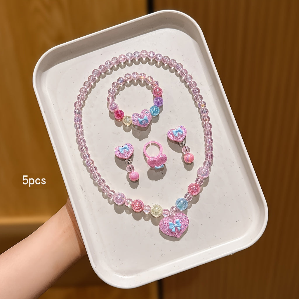 Conjunto de Joyería Infantil de 5 Piezas: Collar, Pulsera, Anillo y Aretes con Dije de Corazón Brillante y Lazo (Tonos Rosas)