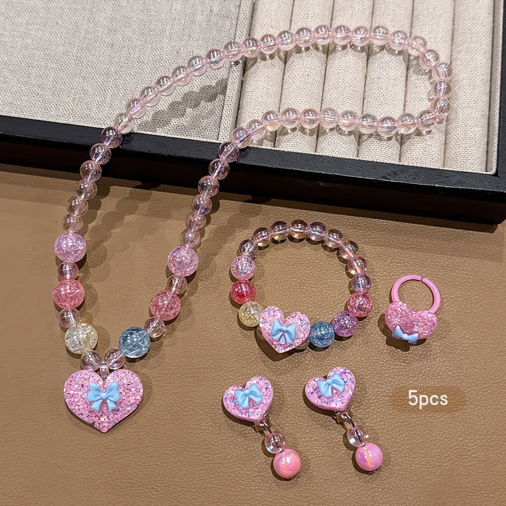 Conjunto de Joyería Infantil de 5 Piezas: Collar, Pulsera, Anillo y Aretes con Dije de Corazón Brillante y Lazo (Tonos Rosas)