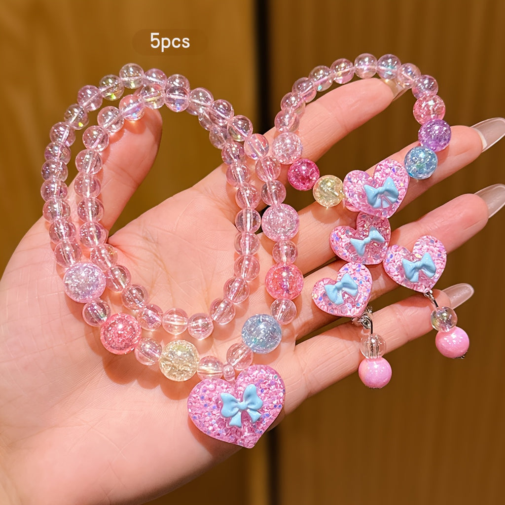 Conjunto de Joyería Infantil de 5 Piezas: Collar, Pulsera, Anillo y Aretes con Dije de Corazón Brillante y Lazo (Tonos Rosas)